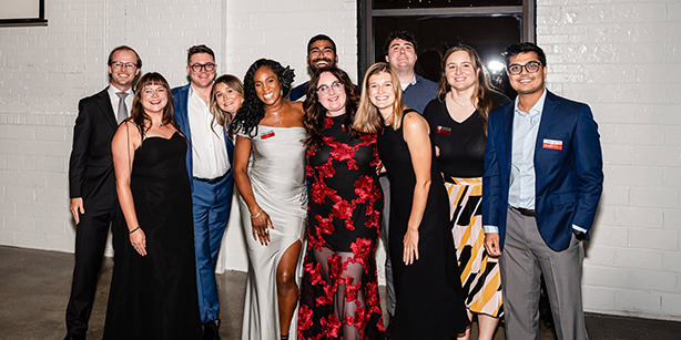 A group of young adults smiling for a photo together